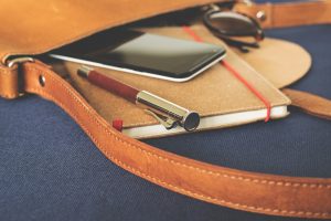鞄にノートとスマホとペンとサングラスが入っている画像